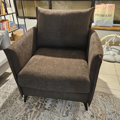 כורסה חומה על שטיח מעוצב בחדר מגורים