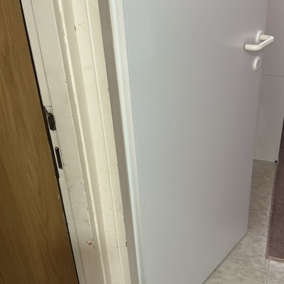 דלת לבנה פתוחה על רצפת קרמיקה