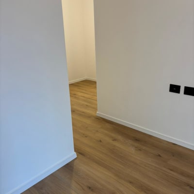 רצפת פרקט בחדר ריק עם קירות לבנים