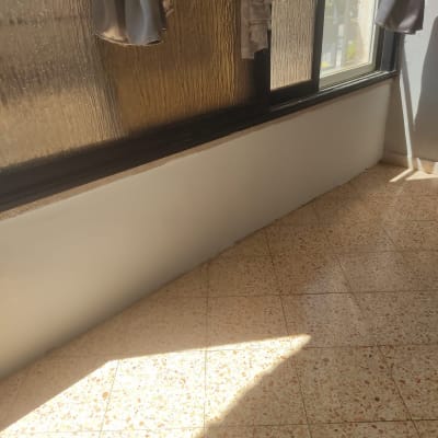קיר צבוע ליד חלון עם וילונות