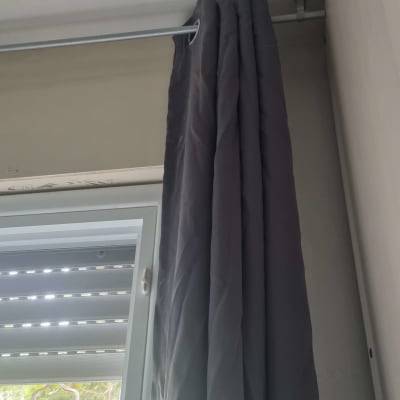 וילון תלוי על מוט מתכת ליד חלון