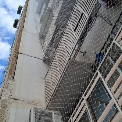 התקנת רשת נגד יונים שקופה לכיסוי מסתורי כביסה בבניין מגורים