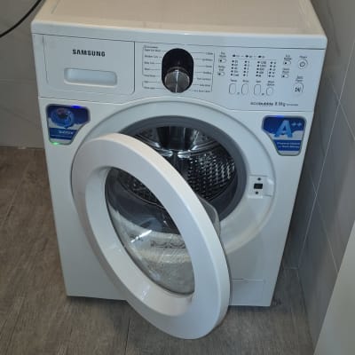 מכונת כביסה עם דלת פתוחה וחיבורים חשמליים