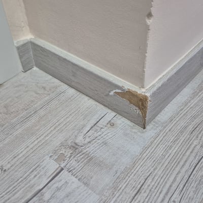 פינת קיר עם פרקט פגום וקרש פאנל