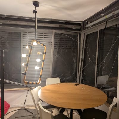 מנורה תלויה מעל שולחן עגול עם כיסאות