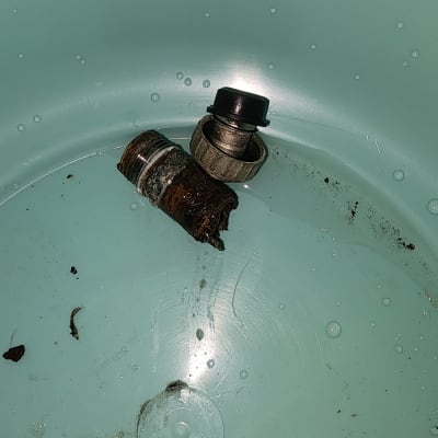 חלקי צינור חלודים ומחברים בתוך דלי