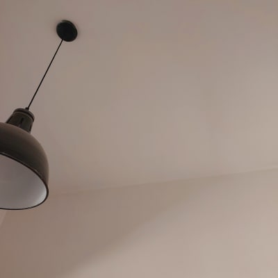 מנורה תלויה מהתקרה על רקע קיר לבן