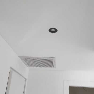 פתח אוורור של מזגן בתקרה לבנה