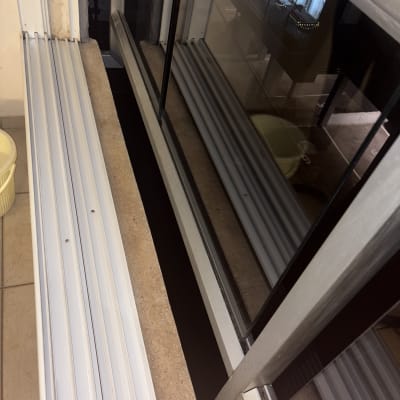 חלון נקי עם מסגרת מתכת ודלי צהוב