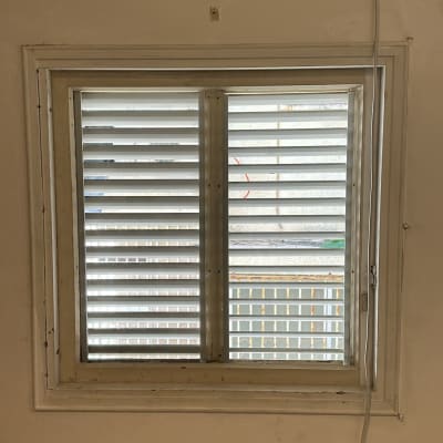 חלון עם תריסים סגורים ומסגרת זכוכית