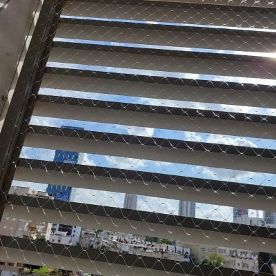 רשת מתכת מותקנת על חלון למניעת כניסת יונים