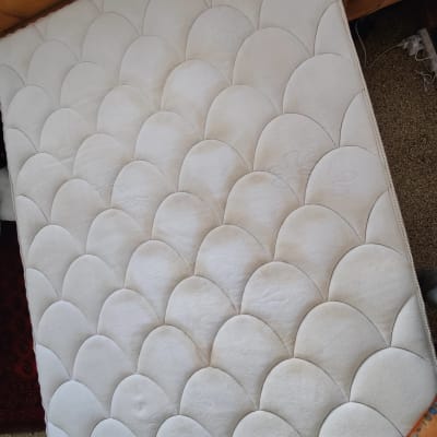 מזרן לבן עם דוגמת קשתות על הרצפה