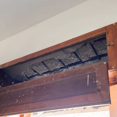 אדם עובד על מסגרת עץ עם קיר בטון חשוף