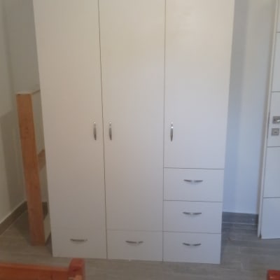 ארון לבן עם דלתות ומגירות בחדר שינה