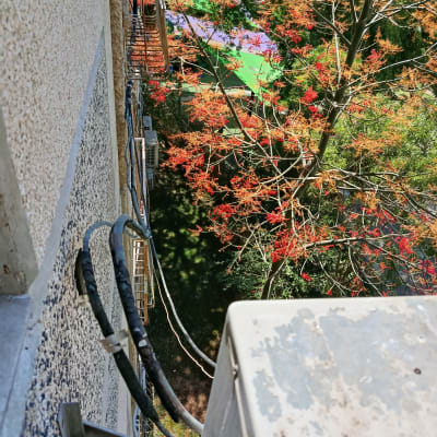 יחידת מזגן מותקנת על קיר חיצוני עם צינורות חיבור.