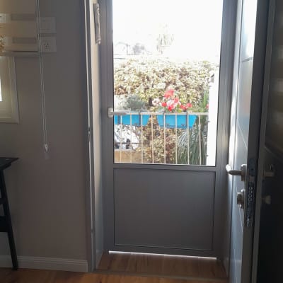 דלת אלומיניום עם ידית לבנה וחלון זכוכית