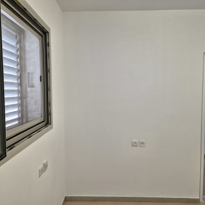 קיר צבוע בלבן עם חלון פתוח