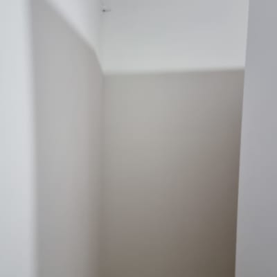 קיר צבוע בלבן עם צללים בחדר קטן