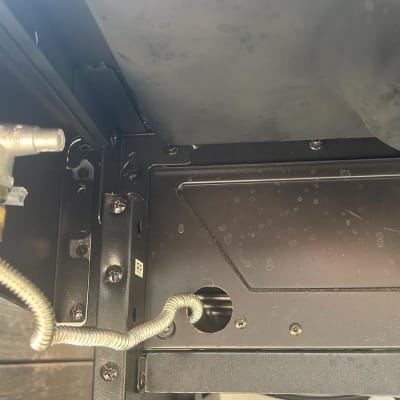 שסתום מתכת עם צינור גמיש בתוך מבנה מתכתי