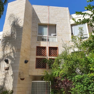 אדם עובד על איטום קיר חיצוני של בניין