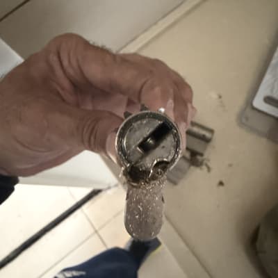 מנעול שבור מוחזק ביד על רצפה