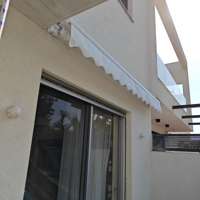 סוכך לבן מותקן מעל חלון זכוכית גדול