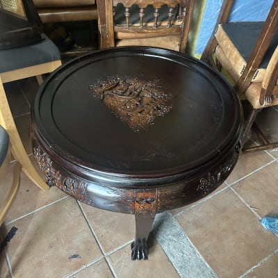 שולחן עץ עגול עם גילופים דקורטיביים על הרגליים