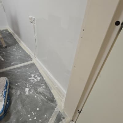 קיר צבוע עם רצפה מכוסה בניילון להגנה.