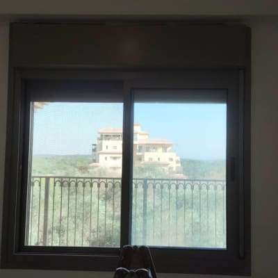 חלון עם נוף חיצוני של בניין ועצים