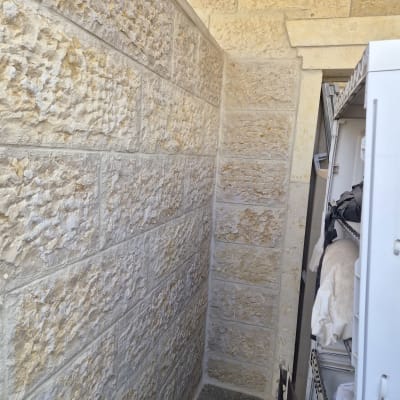 קיר אבן עם מדפים בצד