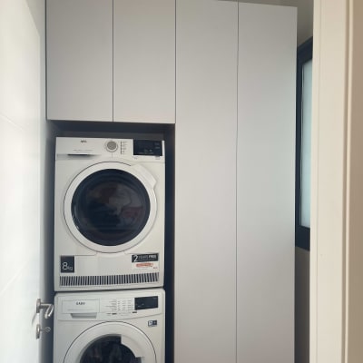 ארון לבן ליד מכונת כביסה ומייבש