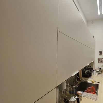 מטבח עם ארונות לבנים, קומקום וכלים על השיש