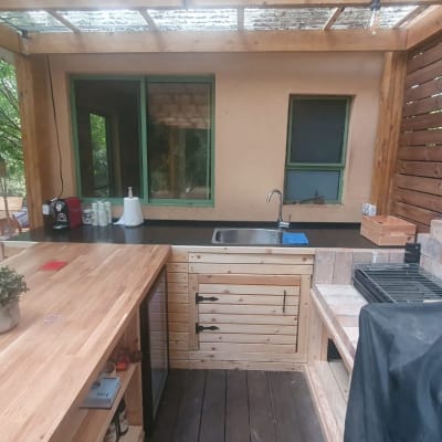 מטבח חוץ עם משטח עבודה מעץ וכיור נירוסטה