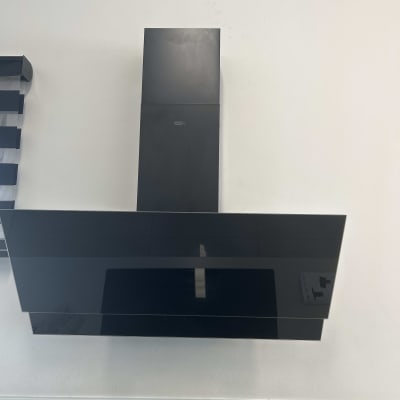 קולט אדים שחור מותקן על קיר לבן