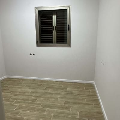 קיר לבן עם חלון, רצפת עץ בהירה