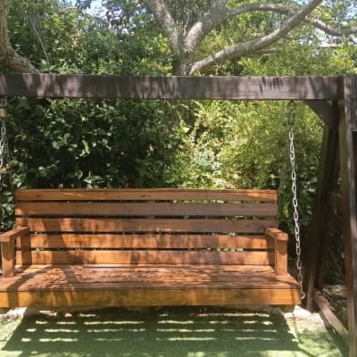 נדנדה מעץ בגינה עם עצים מסביב