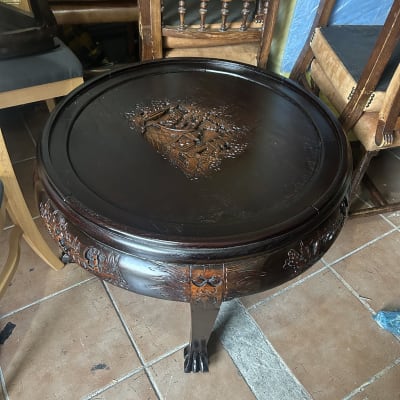 שולחן עץ עגול עם גילופים דקורטיביים על הרגליים