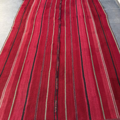 שטיח אדום עם פסים על רצפה אפורה