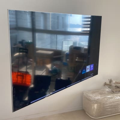 טלוויזיה מותקנת על קיר עם כבלים וכלים מסביב