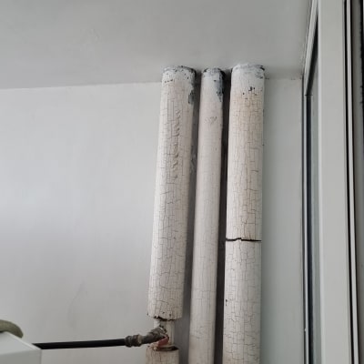 צינורות עם צבע מתקלף על קיר לבן