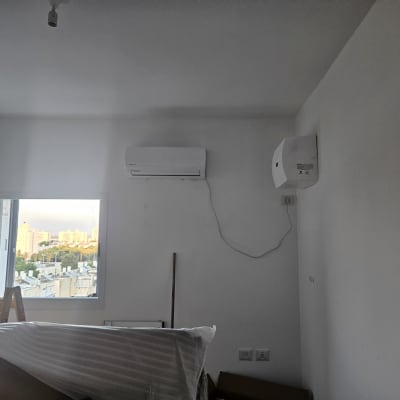 מזגן מותקן על קיר לבן בחדר