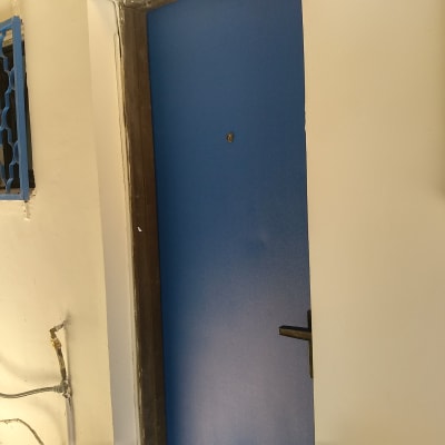 דלת כחולה עם מסגרת מתכת שחורה וקיר צבוע