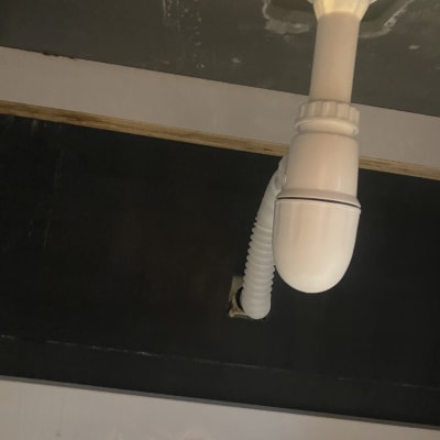 צינור ניקוז לבן מתחת לכיור במטבח