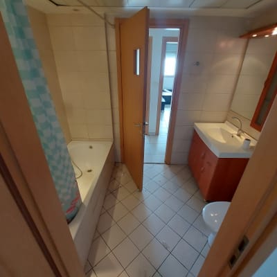 חדר אמבטיה עם כיור, אמבטיה, וילון מקלחת