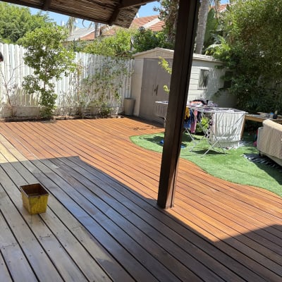 דק עץ עם דלי צהוב בגינה