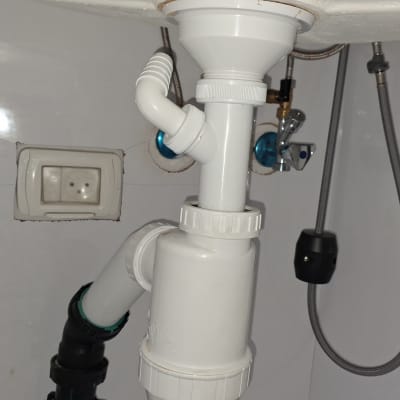 צנרת מתחת לכיור עם חיבורים וברזים