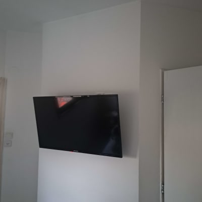 טלוויזיה מותקנת על קיר לבן בחדר