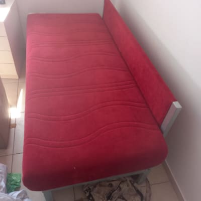 מיטה עם ריפוד אדום בחדר קטן