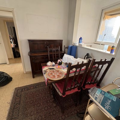 חדר עם שולחן, כיסאות ופריטים שונים על השולחן