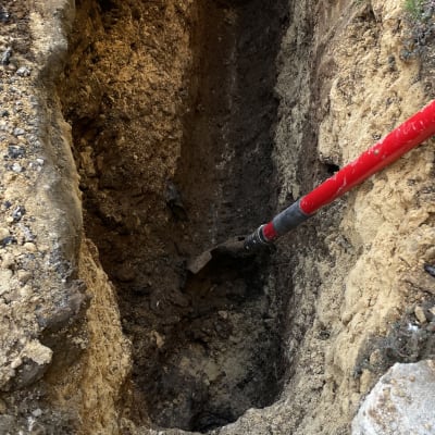 חפירה באדמה עם כלי עבודה אדום